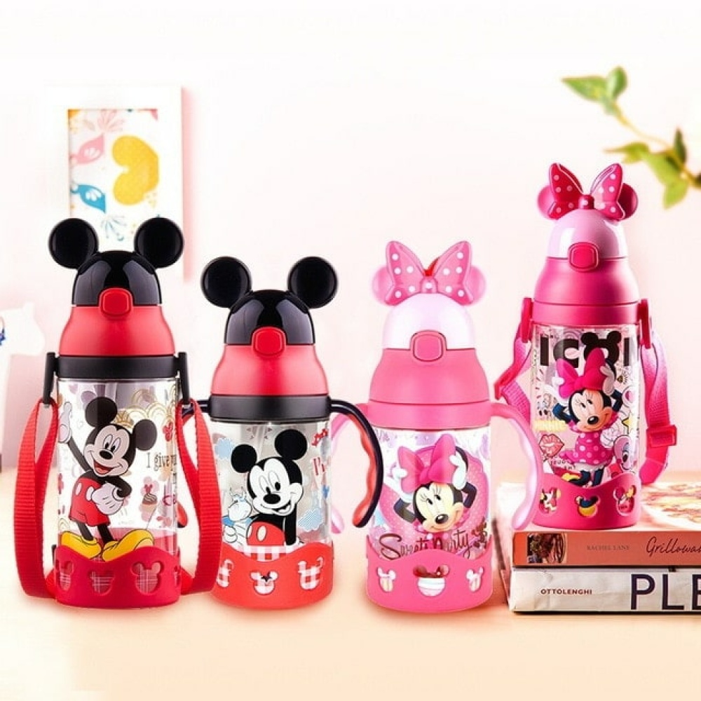 Botella infantil de Mickey en rojo y rosa sobre una mesa con pared blanca