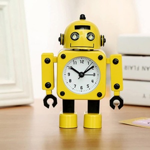 Reloj despertador con forma de robot amarillo sobre mueble marrón con libros