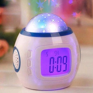 Reloj despertador LED con luz de estrellas multicolor y frente digital sobre una mesa de madera