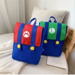 Mochila Super Mario para niños roja y azul, verde y azul sobre una cama con cojín