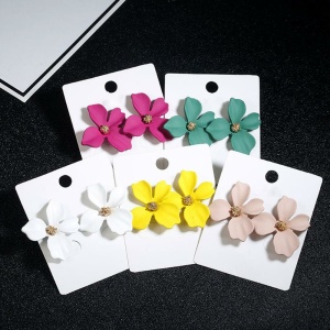 Pendientes en forma de flor para niñas en blanco, amarillo, rosa y verde con etiqueta sobre fondo negro