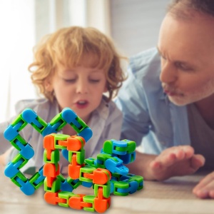 Puzzle de plástico verde, azul y naranja para niños con niño y padre en una habitación para jugar sobre una mesa
