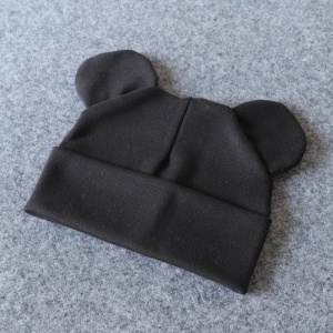 Capota de algodón para bebé con orejitas en negro sobre fondo gris