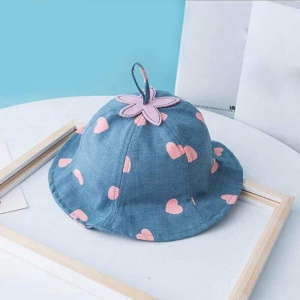 Sombrero de verano de encaje azul para niños con flores rosas sobre una mesa blanca