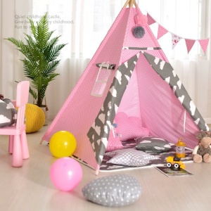 Pequeño tipi blanco y rosa para el dormitorio de un niño con una planta verde y globos en el suelo, con una silla rosa