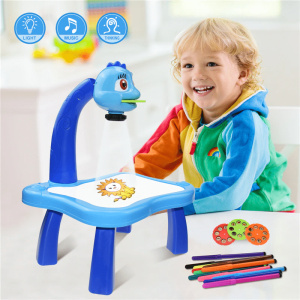 Mesa de dibujo con retroproyector en azul con niño sonriente y bolígrafos de colores