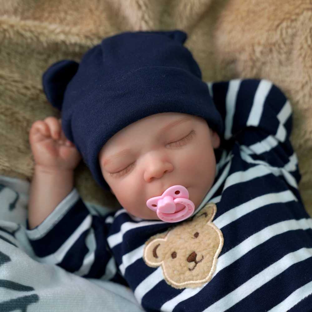 Muñeca bebé reborn de silicona con jersey de rayas azules y chupete