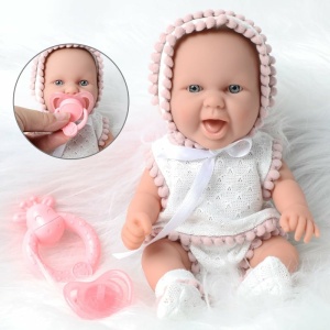 Muñeca vestida con ropa rosa y blanca para recién nacidos sobre una bata blanca
