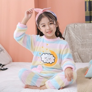 Pijama de forro polar con un colorido motivo de luna para niños con un motivo de nubes en la parte delantera en un salón sobre una alfombra blanca