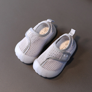Zapatos de playa para niños en malla gris con suela de goma blanca. Tienen un fondo gris oscuro.