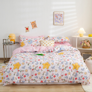 Dormitorio con una cama en el centro, un edredón con motivos rosas y elementos decorativos